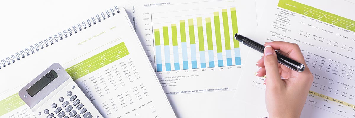 Woman working on her finances, with spreadsheets, graphs and a calculator