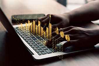 Person working on a laptop displaying a virtual graph of profit and loss