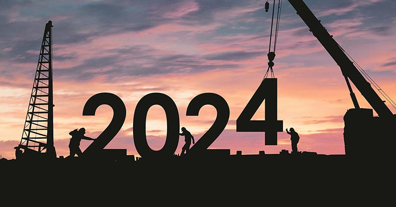 Silhouetted against the skyline of a new dawn, construction workers build '2024'